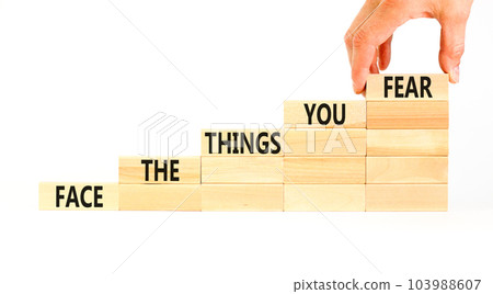 Face the things you fear symbol. Concept words Face the things you fear on wooden blocks on a beautiful white background. Businessman hand. Business and face the things you fear concept. Copy space. Face the things you fear symbol. Concept words Face the things you fear on wooden blocks on a beautiful white background. Businessman hand. Business and face the things you fear concept. Copy space. 103988607