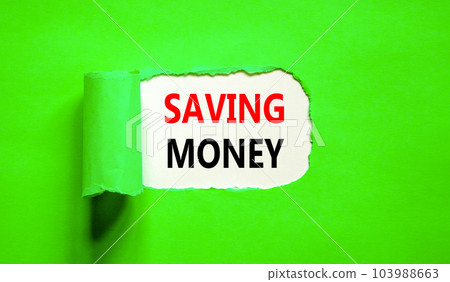 Saving money symbol. Concept words Saving money on beautiful white paper on a beautiful green background. Business, support and saving money concept. Copy space. Saving money symbol. Concept words Saving money on beautiful white paper on a beautiful green background. Business, support and saving money concept. Copy space. 103988663