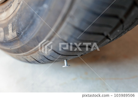 car tire punctured with nails car tire punctured with nails 103989506