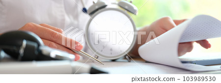 Therapist writes a prescription or fills out medical record for patient in clinic 103989530