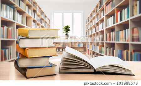 Book stack and open book on the desk in modern public library Book stack and open book on the desk in modern public library 103989578