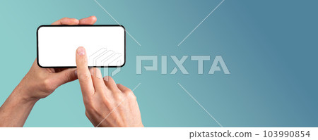 Hand holding smartphone, clicking on blank screen mock-up, tapping on mobile phone display. Banner background with copy space for text 103990854