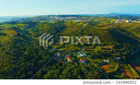 Top view of a European town with beautiful green landscape during sunset. Drone view of a beautiful small European city with a beautiful hilly landscape while sunset.  Portugal. 103990952