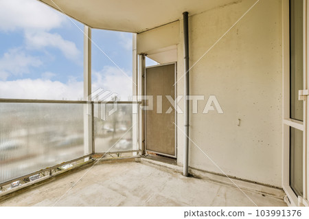 an empty balcony with blue sky and white clouds in the background, taken from inside one of the apartment's windows an empty balcony with blue sky and white clouds in the background, taken from inside one of the apartment's windows 103991376