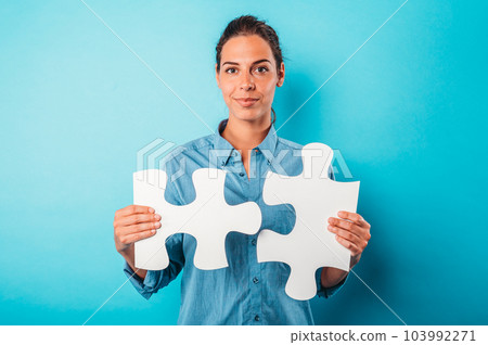 Woman joins piece of puzzle as concept teamwork, partnership, integration 103992271