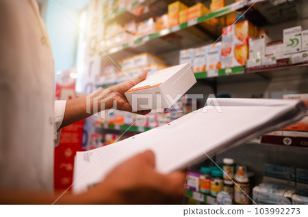 Woman working in the pharmacy looks for the medicine Woman working in the pharmacy looks for the medicine 103992273