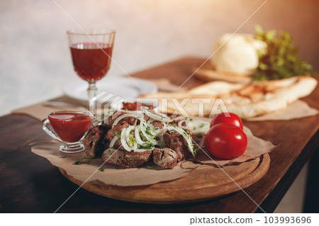 fresh grilled kebab with pork or beef meat, onion, tomato and pita bread 103993696