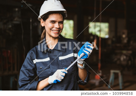 Portrait of happy female industrial worker in white hard hat smiling 103994858