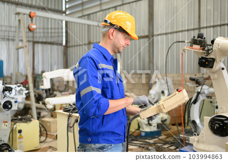 Engineer technician controlling robotic arms on computer laptop 103994863