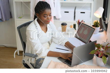 Happy female dressmaker working in workshop studio 103994942