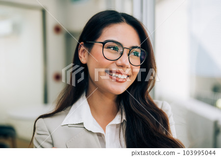 Confident businesswoman enjoying with work at office Confident businesswoman enjoying with work at office 103995044