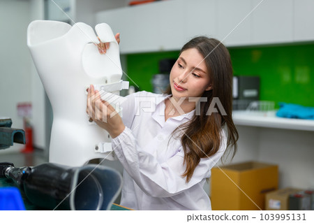 Technician of prosthetic factory fixing prosthetic device in workshop Technician of prosthetic factory fixing prosthetic device in workshop 103995131