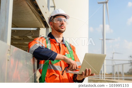 Professional engineer technician working at wind turbine farm field Professional engineer technician working at wind turbine farm field 103995133
