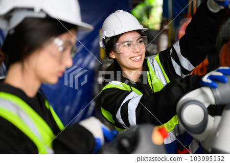 Couple of happy female maintenance engineers working at factory 103995152