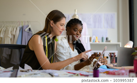 Happy female dressmaker working in workshop studio 103995387