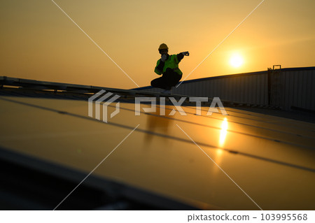 Silhouette of technician engineer checking and repairing solar panels Silhouette of technician engineer checking and repairing solar panels 103995568