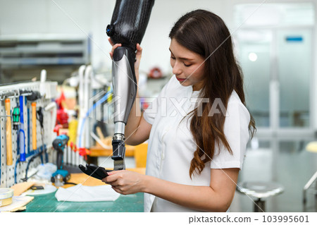 Female technician assembling and fixing parts of modern prosthetic leg Female technician assembling and fixing parts of modern prosthetic leg 103995601