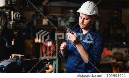 Professional male technician checking and repairing machinery 103995611