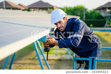 Male technician worker installing solar panels at solar cell farm Male technician worker installing solar panels at solar cell farm 103995821