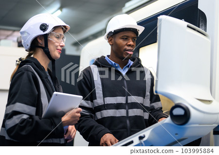 Engineer mechanician operating and controlling CNC machine 103995884