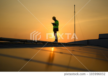 Silhouette of technician engineer checking and repairing solar panels Silhouette of technician engineer checking and repairing solar panels 103996032
