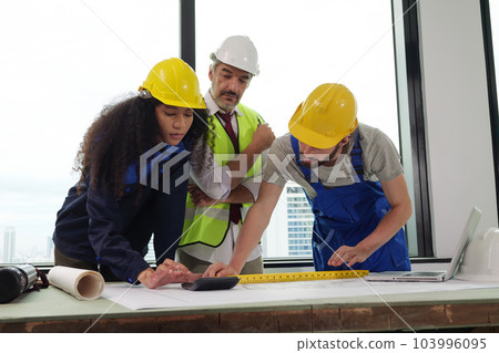 Construction engineers team using blueprint of project plan 103996095