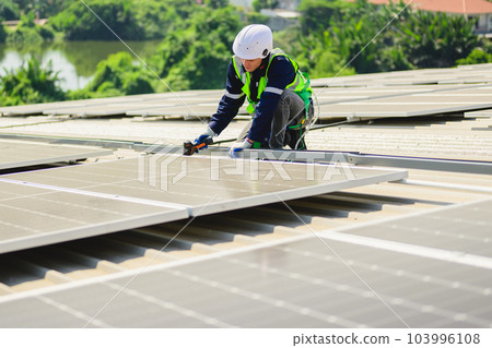 Engineers with safety helmet checking solar system at solar power farm 103996108