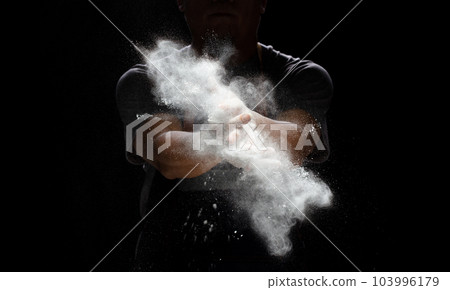 Chef prepare white flour dust for cooking bakery food. Elderly man Chef clap hand, white flour dust explode fly in air. Flour stop motion in air with freeze high speed shutter, black background Chef prepare white flour dust for cooking bakery food. Elderly man Chef clap hand, white flour dust explode fly in air. Flour stop motion in air with freeze high speed shutter, black background 103996179