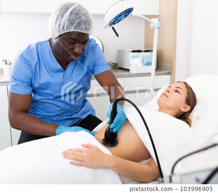Young beautiful woman getting body ultrasound lifting procedure 103996905