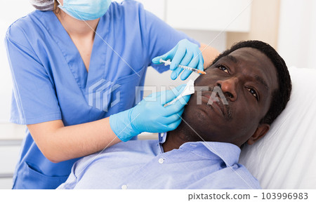 Man getting procedure of injection for face skin tightening 103996983
