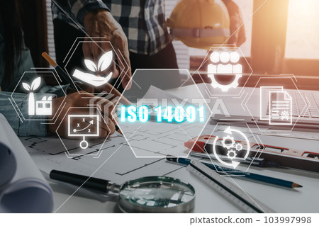 ISO 14001 certified environmental management systems concept, Engineer team working on office desk with iso 14001 icon on virtual screen. ISO 14001 certified environmental management systems concept, Engineer team working on office desk with iso 14001 icon on virtual screen. 103997998