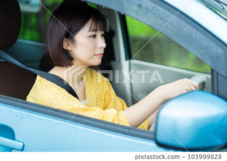 A woman driving a car A woman sitting in the driver's seat of a car A woman driving a car A woman sitting in the driver's seat of a car 103999828