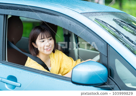 A woman driving a car A woman sitting in the driver's seat of a car A woman driving a car A woman sitting in the driver's seat of a car 103999829