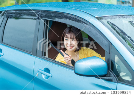 A woman driving a car A woman sitting in the driver's seat of a car A woman driving a car A woman sitting in the driver's seat of a car 103999834