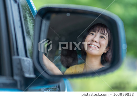 一個女人在開車 一個女人坐在汽車的駕駛座上 一個女人在開車 一個女人坐在汽車的駕駛座上 103999838