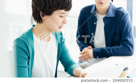 Young men and women having a meeting while looking at a computer Young men and women having a meeting while looking at a computer 104000353