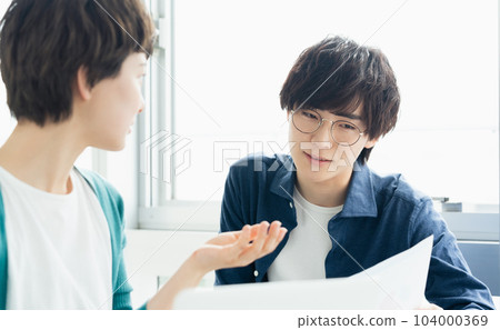 年輕男女一邊看電腦一邊開會 104000369