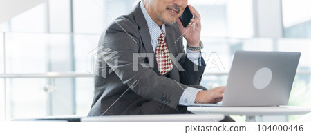 中年商人（老闆、總裁、領導）在辦公室用智能手機交談 104000446