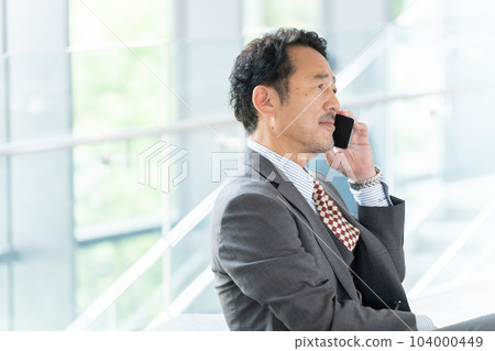 中年商人(老闆、總裁、領導)在辦公室用智能手機交談 中年商人(老闆、總裁、領導)在辦公室用智能手機交談 104000449