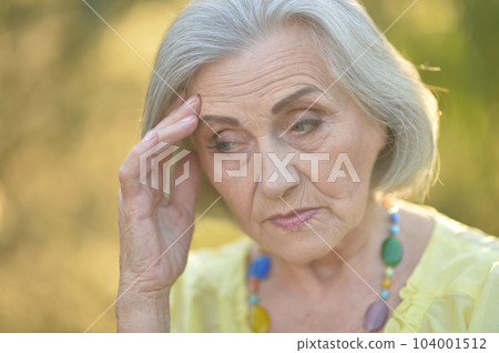 Portrait of an unhappy woman of middle age 60-75 years old with blond hair, sad eyes Portrait of an unhappy woman of middle age 60-75 years old with blond hair, sad eyes 104001512