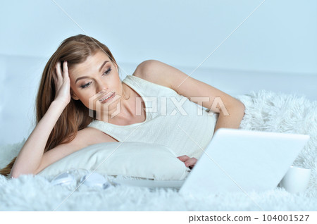 young woman with cup of coffee and laptop 104001527