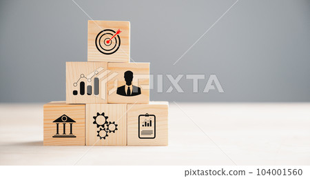 Business target concept on wooden block cude step. Action Plan and Goal icons symbolize success. Project management and company strategy on a table. Professional background. 104001560