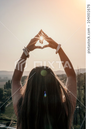 Fitness woman. Happy middle-aged fitness woman doing stretching and pilates on a rock near forest at sunset. Female fitness yoga routine. Healthy lifestyle with focus on well-being and relaxation. Fitness woman. Happy middle-aged fitness woman doing stretching and pilates on a rock near forest at sunset. Female fitness yoga routine. Healthy lifestyle with focus on well-being and relaxation. 104001676