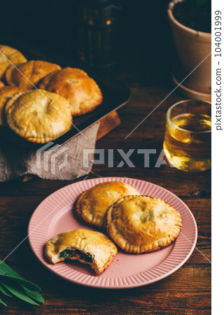 Oven Baked Pastries Filled with Chives and Mushrooms. One with Bite Taken Out of It Oven Baked Pastries Filled with Chives and Mushrooms. One with Bite Taken Out of It 104001999