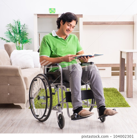 Young handsome man in wheelchair at home 104002301