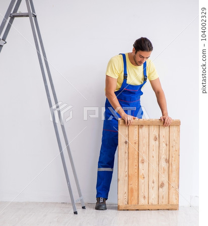Young male contractor working indoors 104002329
