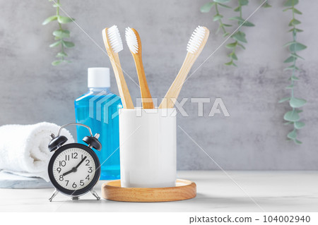 Oral and dental care background, bamboo toothbrush and clock with  mouthwash and towel 104002940