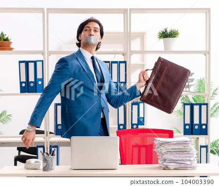 Young male employee with tape on the mouth Young male employee with tape on the mouth 104003390