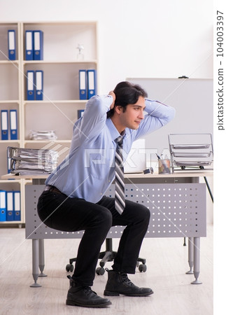 Young handsome male employee doing exercises in the office Young handsome male employee doing exercises in the office 104003397
