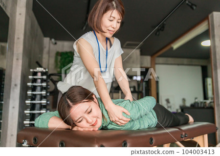 A woman who is a sports therapist and sports trainer who massages 104003413